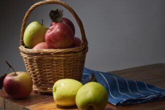 Alma fonott kosárban rusztikus fa asztalon