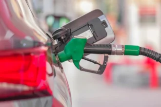 Tankolópisztoly egy autó tanknyílásában a benzinkúton