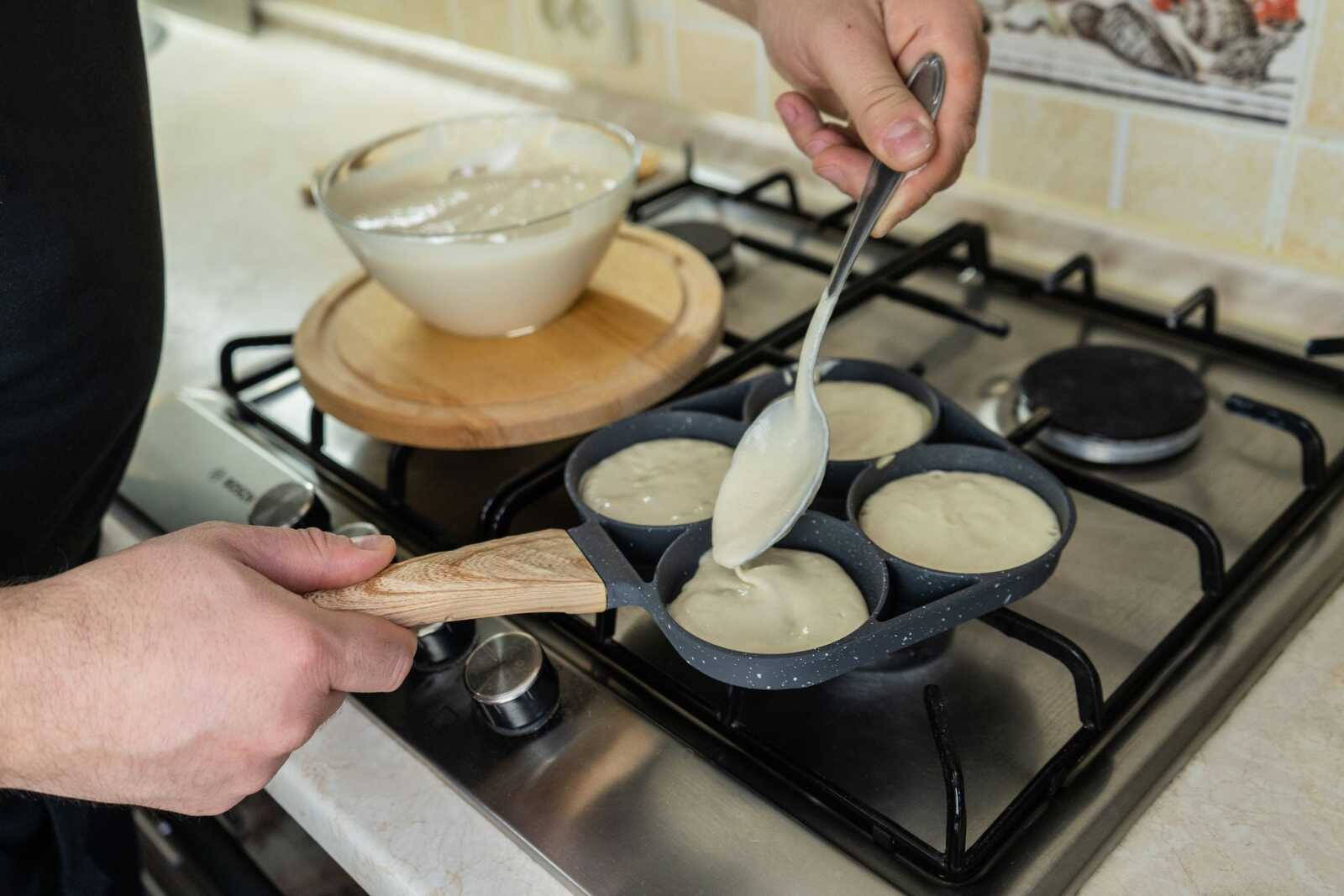 Palacsintatészta kerül a forró serpenyőbe merőkanállal