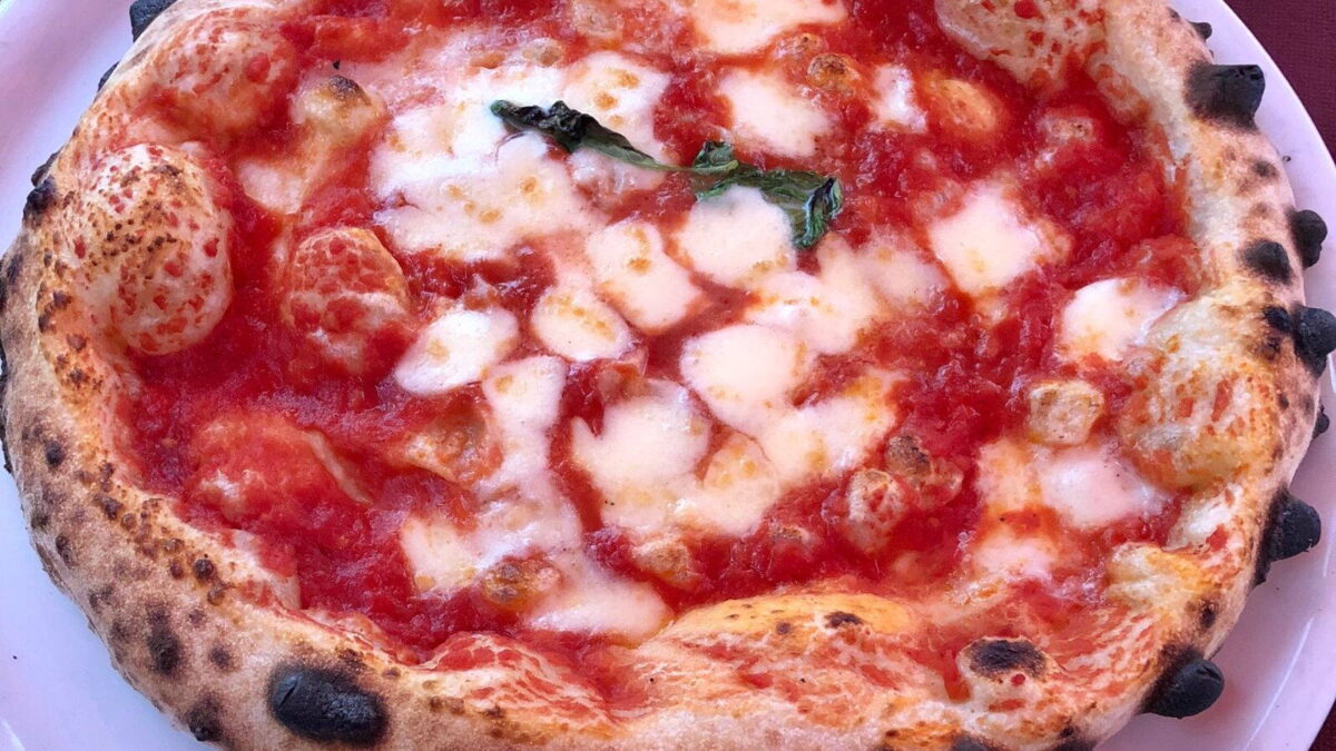 Kerek nápolyi pizza magasra sült, foltos peremmel