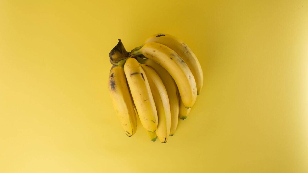 Érett sárga banánfürt sárga háttér előtt