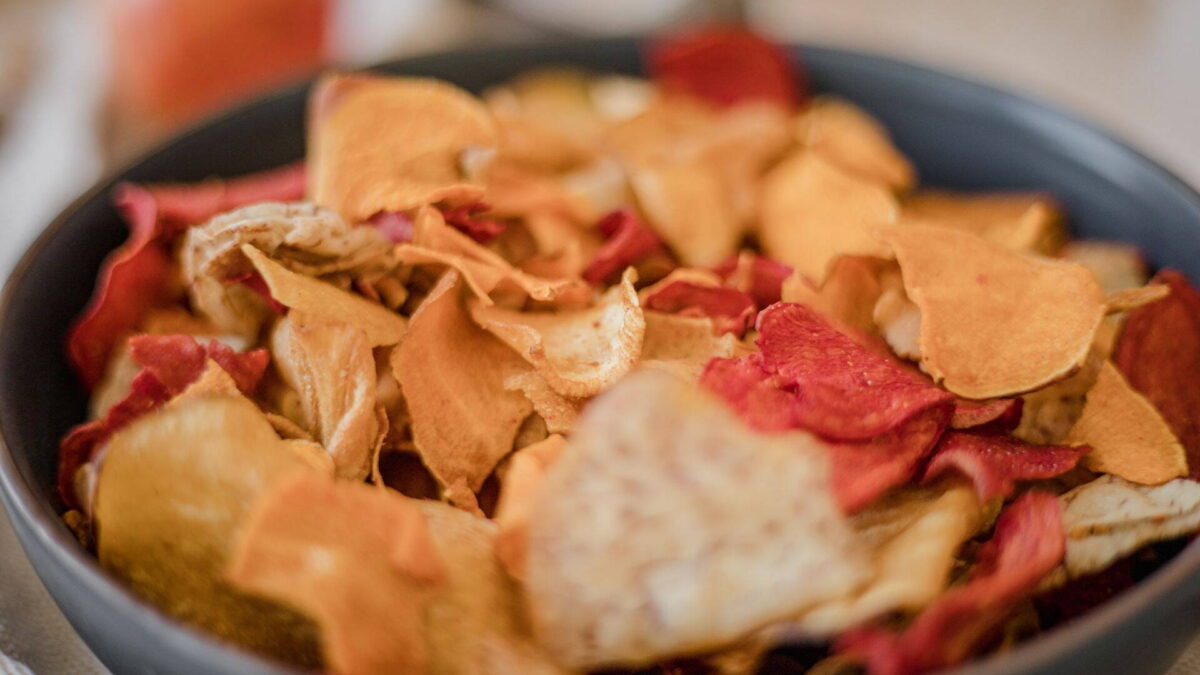 Házi zöldségchips egy fekete tálban, köztük céklaszeletek